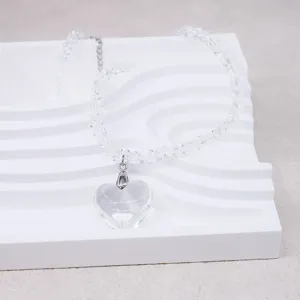 Transparent crystal heart pendant necklace detail, elegant beaded clavicle chain jewelry piece.