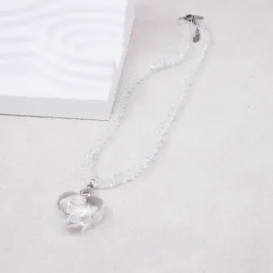 Close-up detail of the clear crystal heart pendant necklace with beaded chain layout.