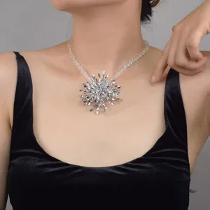 Close up of a sparkling crystal starburst pendant necklace detail shot worn on neck.