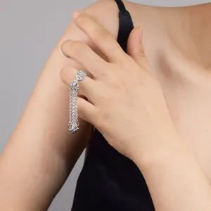 Close-up detail shot of the elegant bow tassel ring worn gracefully on finger, sparkling zircon.