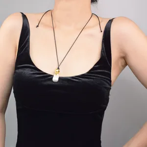 Vue détaillée du pendentif perle baroque avec fermoir en métal doré sur un cordon.