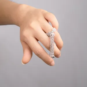 Detailed close-up view of silver bow zircon tassel ring worn on finger for elegance