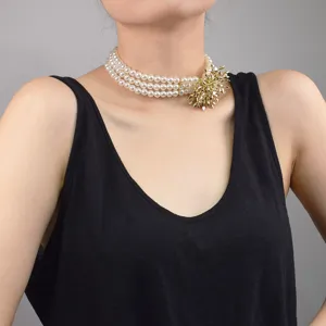 Three-layer faux pearl choker necklace with gold spiky ball pendant, elegant party jewelry.