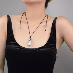 Élégant collier de perles baroques imitation avec pendentif griffe métal cordon noir.