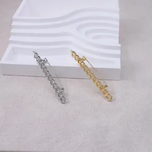 Detailed view of stylish chain brooch pins in silver and gold, perfect for coats and suits.