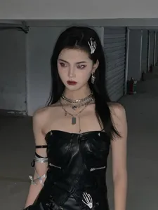 Gothic skeleton hand hair clip detail shot, punk style metal necklace and dark outfit accessory view.