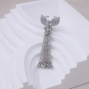 Close-up of silver bowknot open ring with sparkling zircon and long chain tassels.
