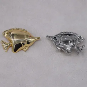 Close-up detail of vintage tropical fish brooch, showing gold front and silver pin back.