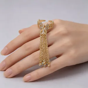 Detailed shot of gold bow tassel ring, sparkling zircon stones, elegant open design style.
