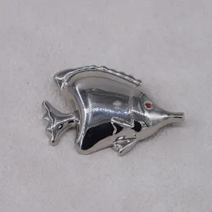 Detailed view of silver tropical fish brooch, vintage ocean animal lapel pin accessory.
