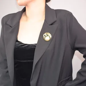 Detail view of French vintage pearl brooch featuring irregular metal texture on black blazer.
