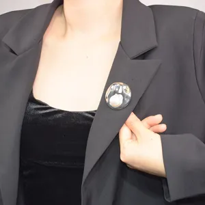 French vintage shell pearl brooch with metallic pleated texture, elegant suit lapel pin accessory.