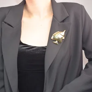 Detailed view of the gold-tone tropical fish brooch, ideal for blazers and coats.