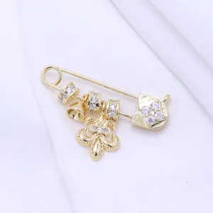 Gold-plated safety pin charm with fleur-de-lis and crystals, DIY handmade jewelry accessory.