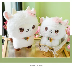 Plush alpaca toy detail view showing soft white fabric, pink flower headwear, and cute facial design.