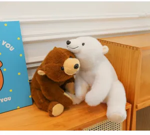 Close-up detail of cute brown and white plush polar bear and bear hugging toys on desk.