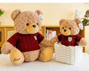 Vue détaillée de mignons ours en peluche bruns portant des pulls en tricot rouge dans la pièce.