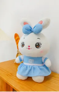 Detailed view of the cute plush rabbit toy wearing a soft blue dress and a lovely bow.