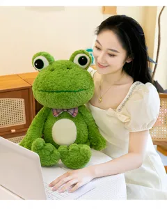 Detail view of a cute green frog plush toy sitting with a smiling model, soft stuffed doll.