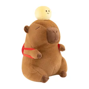 Schattige capybara pluche knuffel met rode rugzak en gele bal op het hoofd voor kinderen.