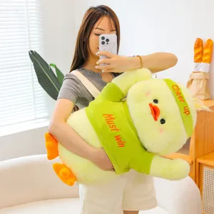 Cute yellow duck plush toy doll, soft huggable stuffed animal pillow with green outfit for kids.