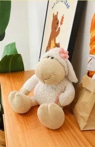 Detail view of cute plush sheep doll toy with pink flower, soft and fluffy fabric for kids.