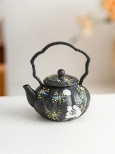 Detailed view of handmade black ceramic teapot featuring cute rabbit and osmanthus pattern.