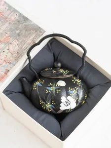 Detailed view of black ceramic teapot featuring cute rabbit and osmanthus floral pattern.