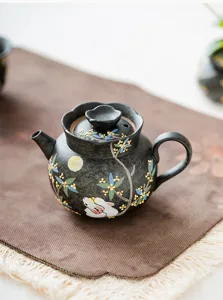 Hand-painted osmanthus rabbit teapot detail, black ceramic single tea maker closeup view.