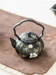 Detail view of the black ceramic rabbit and moon tea pot with unique handle design.