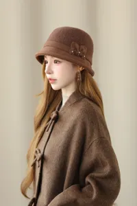Retro brown wool bucket hat featuring chic floral decoration and cozy winter design.