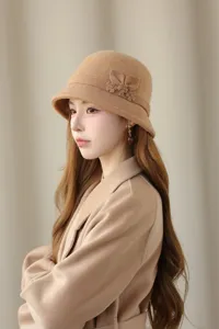Detail shot of elegant camel wool felt bucket hat featuring delicate side flower decoration.