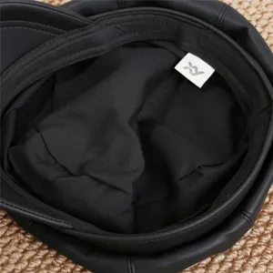Detailed view of the black faux leather octagonal hat interior lining and brand tag.