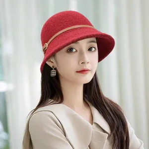 Detailed view of the red knitted bucket hat, featuring a stylish brown leather strap and metal ring.