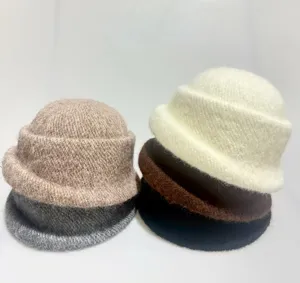 Close-up detail of cozy faux rabbit hair knit bucket hats stacked in various stylish solid colors.