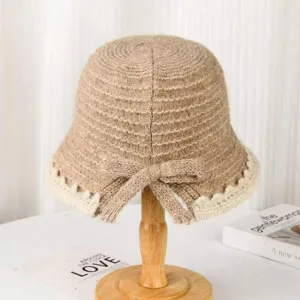 Detail view of a knitted bucket hat with lace brim edge and bow knot decoration in autumn.