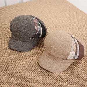 Detailed view of Japanese retro newsboy caps in dark grey and khaki with plaid patch design.