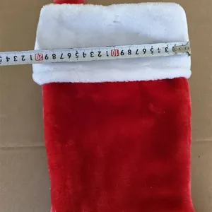 Large red plush Christmas stocking holiday gift bag fluffy home decoration detail view.