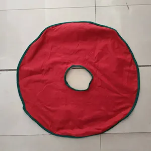 Red and green non-woven Christmas tree skirt detail shot, festive holiday tree base cover decor.