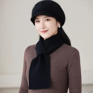 Close-up detail of the black knitted beret and scarf set, showing soft texture and cozy warmth.