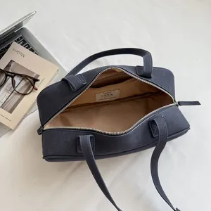 Detailed view of the minimalist solid color Boston handbag showing inner lining and capacity.