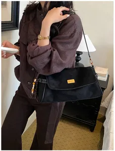 Sac à bandoulière noir vintage pour femme, sac croisé rétro avec détail métallique élégant.