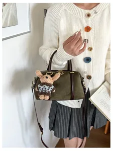 Retro sudede schouderkussen tas detail, donkergroene handtas met schattige pluche hanger.