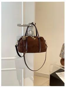 Vintage bruine sude schoudertas detail, elegante kussen tas met metalen gesp en hanger.