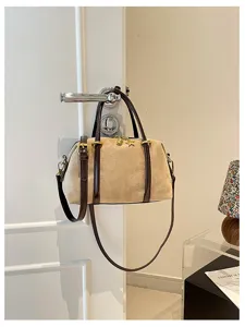 Vintage beige suède schoudertas voor dames, retro kussen handtas met donkerbruine bandjes.