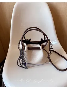 Λεπτομερής απεικόνιση της τσάντας κάδος σε vintage στιλ με χερούλι και ρυθμιζόμενο λουρί.