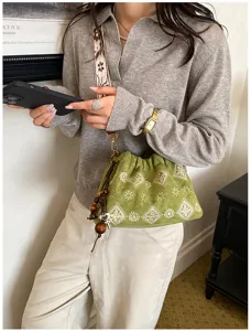Vintage green embroidered drawstring handbag with ethnic shoulder strap and wooden bead charms.