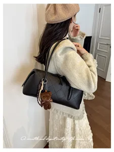 Elegante borsa a tracolla trapuntata nera con grazioso ciondolo a forma di orsetto per autunno.