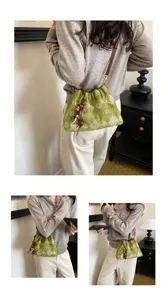 Retro green suede shoulder bag with paisley print and wooden bead pendant, casual detail view.