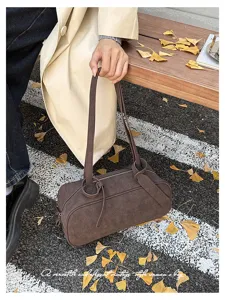 Vintage brown cylindrical shoulder bag for women, elegant faux leather Boston bag for autumn commuting.